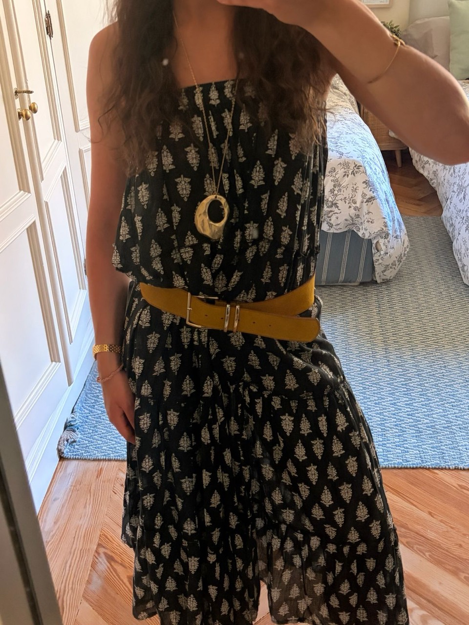 Black floral block-print maxi dress with a mustard belt and gold pendant